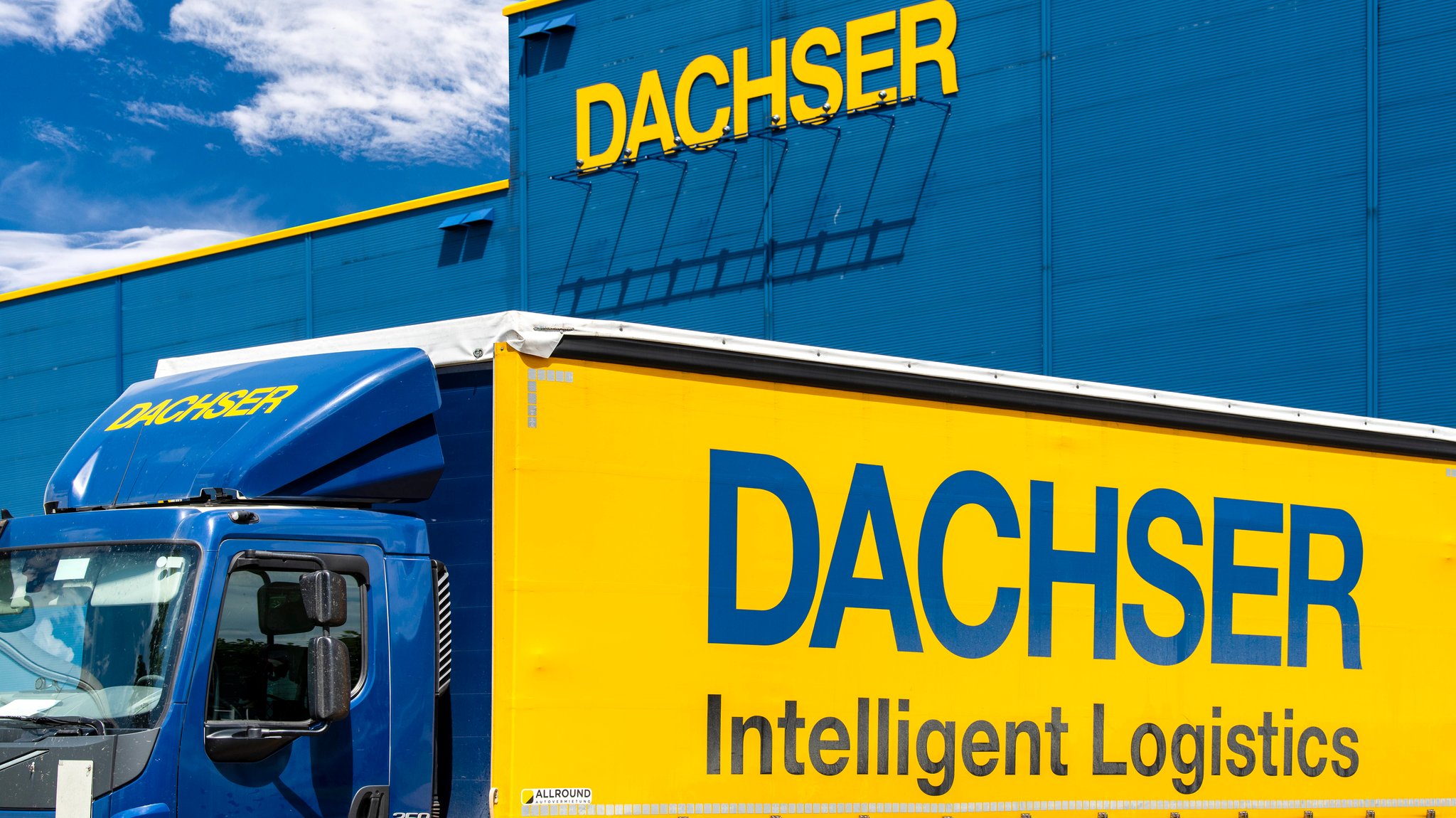 Ein LKW vor einem Gebäude, auf dem das Schild "Dachser" zu lesen ist