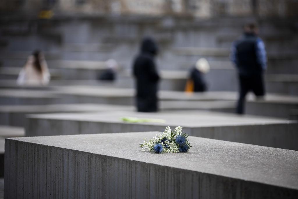 27.01.2024, Berlin: Blumen liegen anlässlich des Internationalen Tags des Gedenkens an die Opfer des Holocaust auf einer Stele des Denkmals für die ermordeten Juden Europas. Foto: Christoph Soeder/dpa +++ dpa-Bildfunk +++