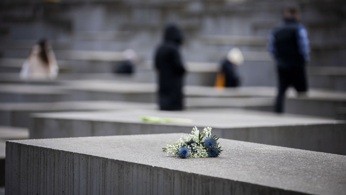 27.01.2024, Berlin: Blumen liegen anlässlich des Internationalen Tags des Gedenkens an die Opfer des Holocaust auf einer Stele des Denkmals für die ermordeten Juden Europas. Foto: Christoph Soeder/dpa +++ dpa-Bildfunk +++