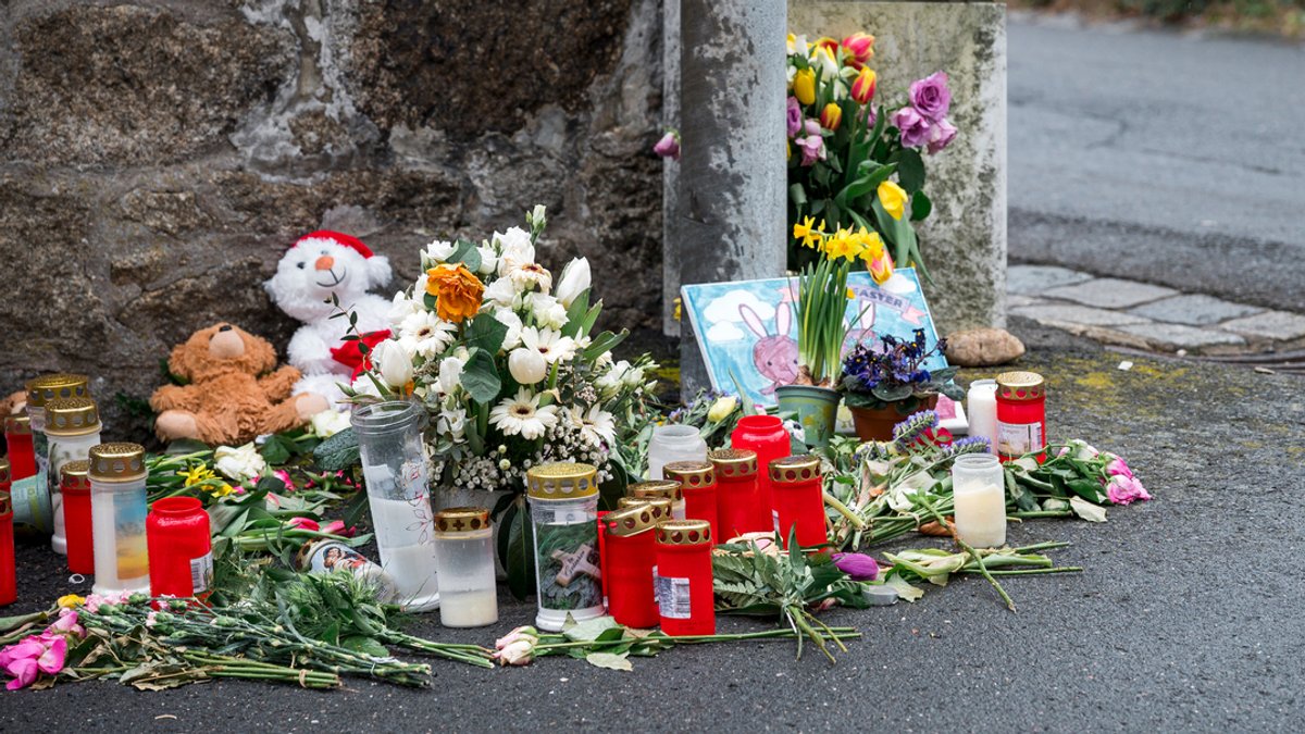 Blumen, Kerzen und Teddybären an einer Mauer erinnern an den Tod eines Kindes. 