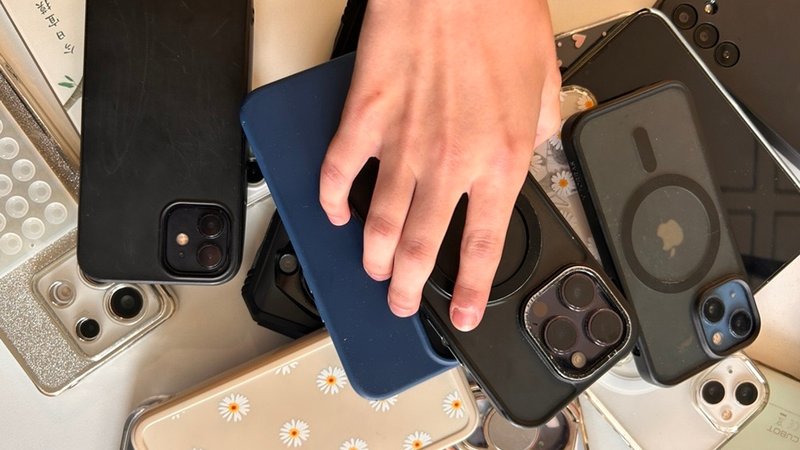 Hand legt ein Smartphone auf einen Stapel mit Smartphones auf einem Lehrerpult. | Bild: BR/Meike Föckersperger Hand legt ein Smartphone auf einen Stapel mit Smartphones auf einem Lehrerpult.