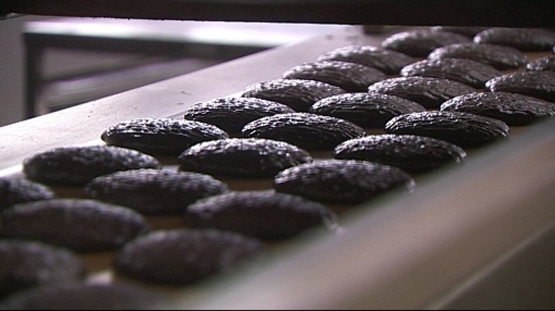 Lebenkuchen mit Schokoladenglasur auf einem Produktionsband. Im Hochsommer läuft die Herstellung auf Hochtouren. | Bild: BR/Michael Zehetmair Lebenkuchen mit Schokoladenglasur auf einem Produktionsband. Im Hochsommer läuft die Herstellung auf Hochtouren.