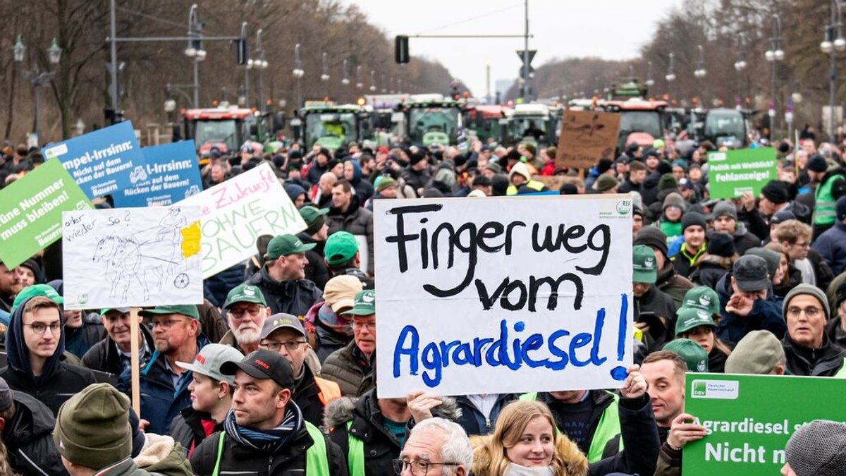 Auf einer Demonstration des Deutschen Bauernverbandes unter dem Motto "Zu viel ist zu viel! Jetzt ist Schluss!" vor dem Brandenburger Tor hält jemand am 18. Dezember ein Schild mit der Aufschrift "Finger weg vom Agrardiesel" hoch.