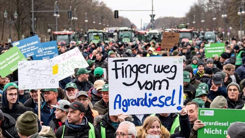 Auf einer Demonstration des Deutschen Bauernverbandes unter dem Motto "Zu viel ist zu viel! Jetzt ist Schluss!" vor dem Brandenburger Tor hält jemand am 18. Dezember ein Schild mit der Aufschrift "Finger weg vom Agrardiesel" hoch.