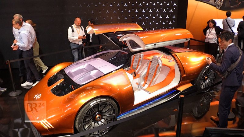 Ein zimtfarbenes Elektroauto auf einer Messe. | Bild: Bayerischer Rundfunk 2024 Ein zimtfarbenes Elektroauto auf einer Messe.