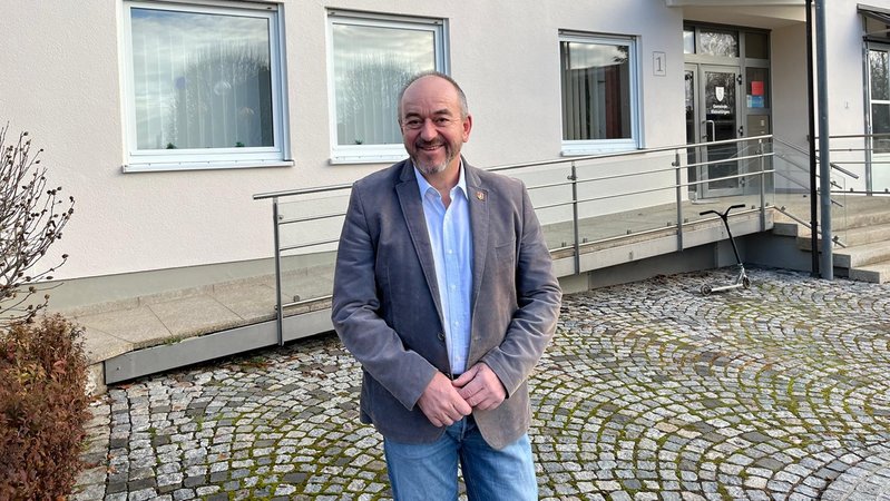 Rupert Fiehl, Bürgermeister von Kleinaitingen, lächelt in die Kamera. | Bild: Leinfelder/BR Rupert Fiehl, Bürgermeister von Kleinaitingen, lächelt in die Kamera.