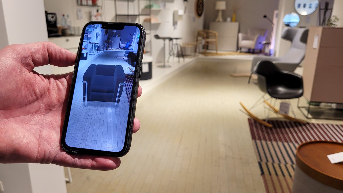 Smartphone, auf dem per Augmented Reality ein Möbelstück im Raum präsentiert wird.