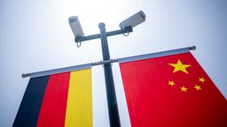 Überwachungskameras sind über der deutschen und der chinesischen Flagge vor der Tongji-Universität, China  | Bild:picture alliance/dpa | Michael Kappeler
