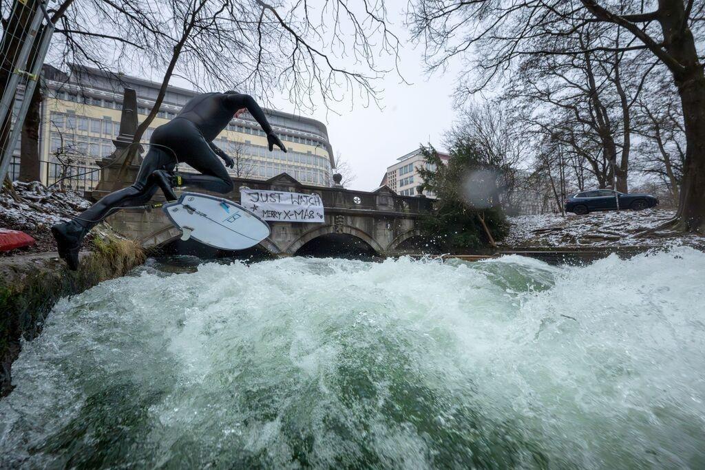 (Archivbild) Bayern, München: Ein Mann versucht mit einem großen Sprung auf Eisbachwelle im Englischen Garten zu springen.