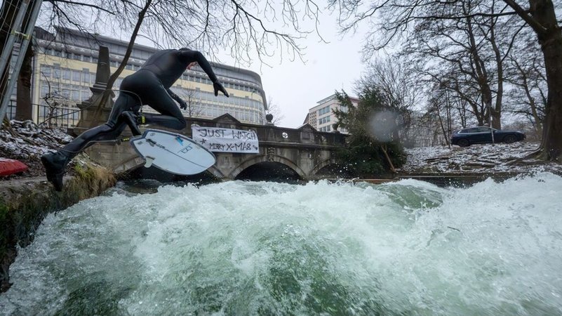 (Archivbild) Bayern, München: Ein Mann versucht mit einem großen Sprung auf Eisbachwelle im Englischen Garten zu springen. | Bild: dpa-Bildfunk/Peter Kneffel (Archivbild) Bayern, München: Ein Mann versucht mit einem großen Sprung auf Eisbachwelle im Englischen Garten zu springen.