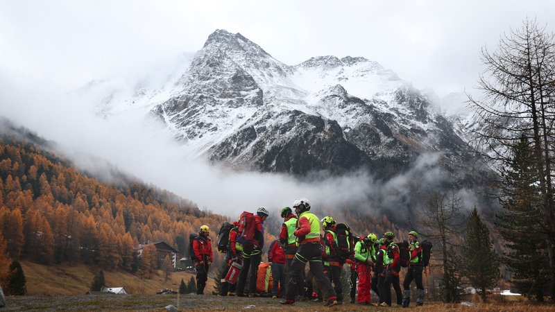 Mitglieder der Bergrettung warten vor den verschneiten Bergen des Ortlergebirges auf den Rettungshubschrauber. | Bild: picture alliance/dpa | Karl-Josef Hildenbrand Mitglieder der Bergrettung warten vor den verschneiten Bergen des Ortlergebirges auf den Rettungshubschrauber.