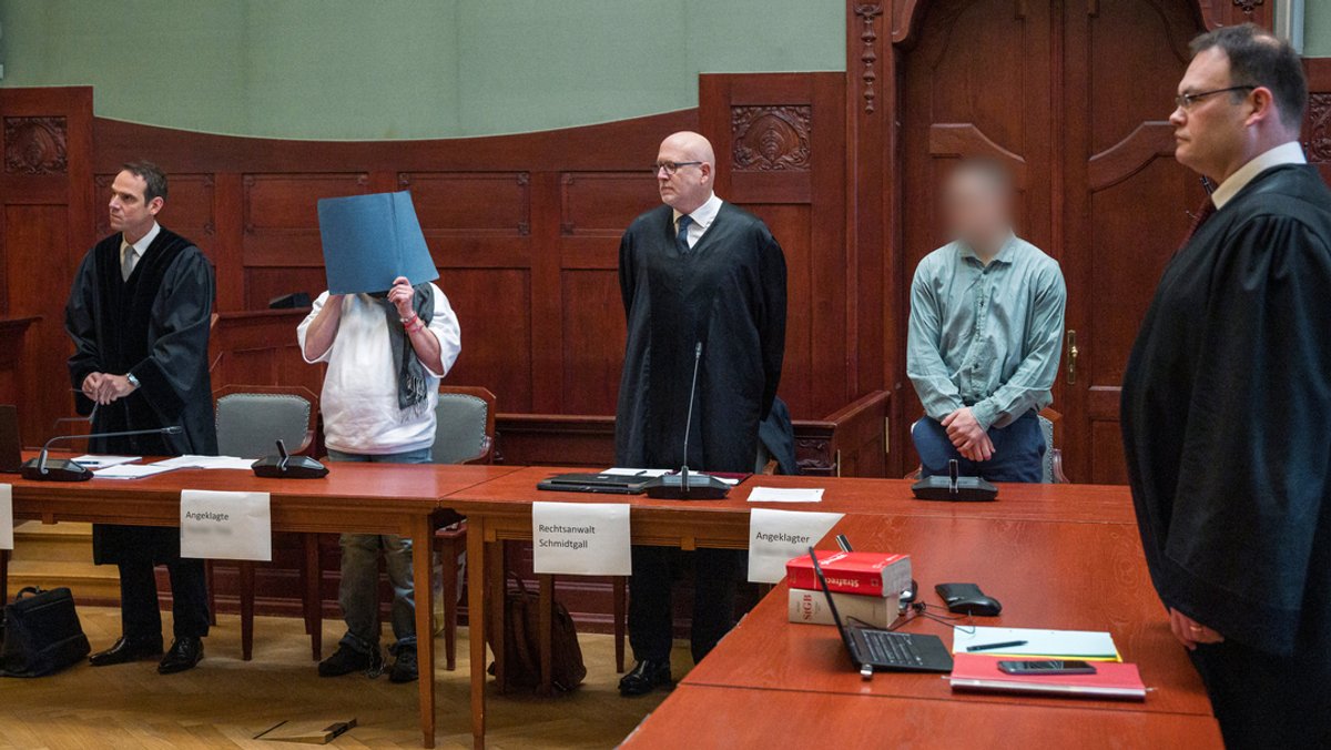 Rechtsanwälte und Angeklagte erheben sich zu Beginn einer Verhandlung im Verhandlungssaal im Landgericht Bayreuth.