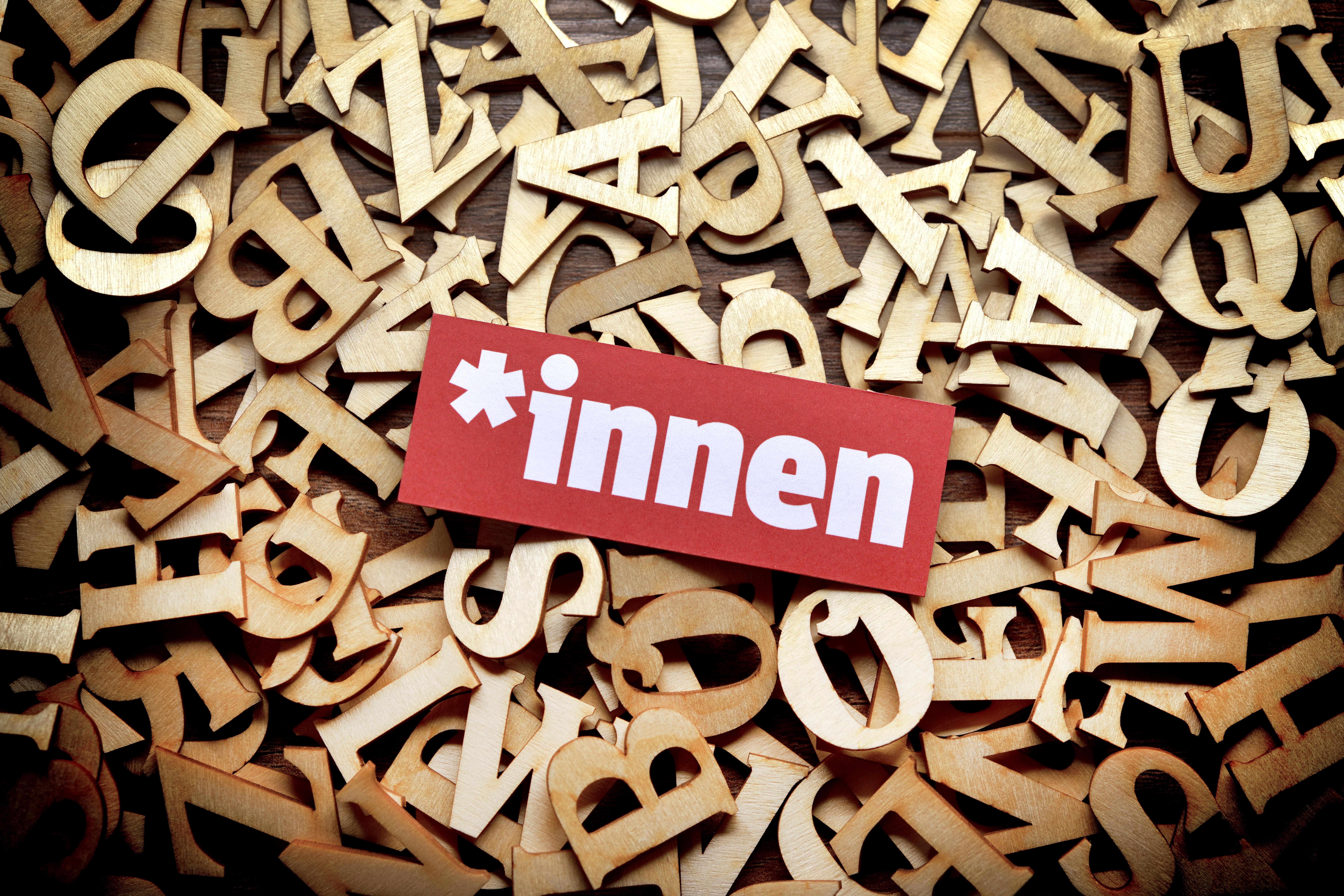 Gendersternchen und Schriftzug "*innen" auf Buchstaben (Symbolbild)