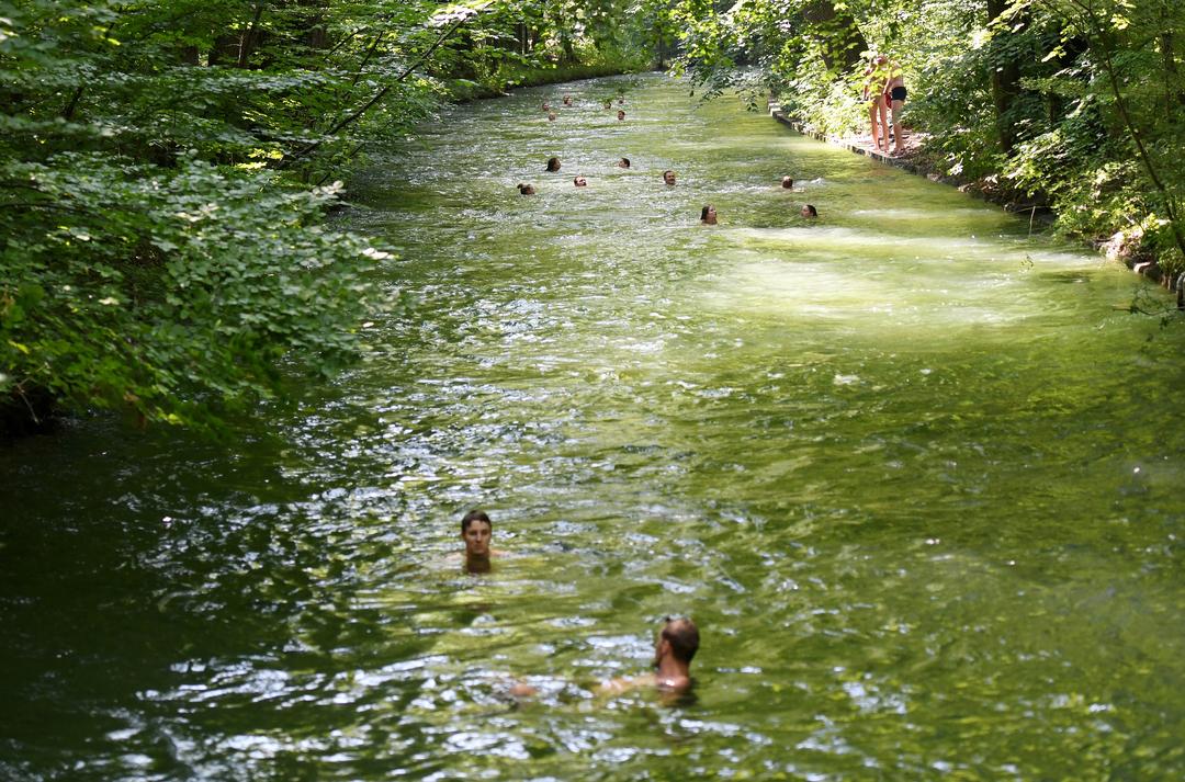 Zu sehen sind Badegäste im Eisbach in München