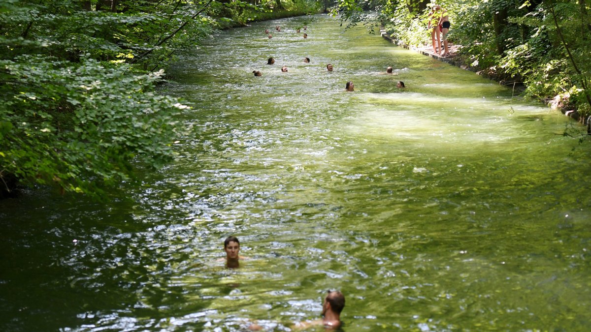 Zu sehen sind Badegäste im Eisbach in München