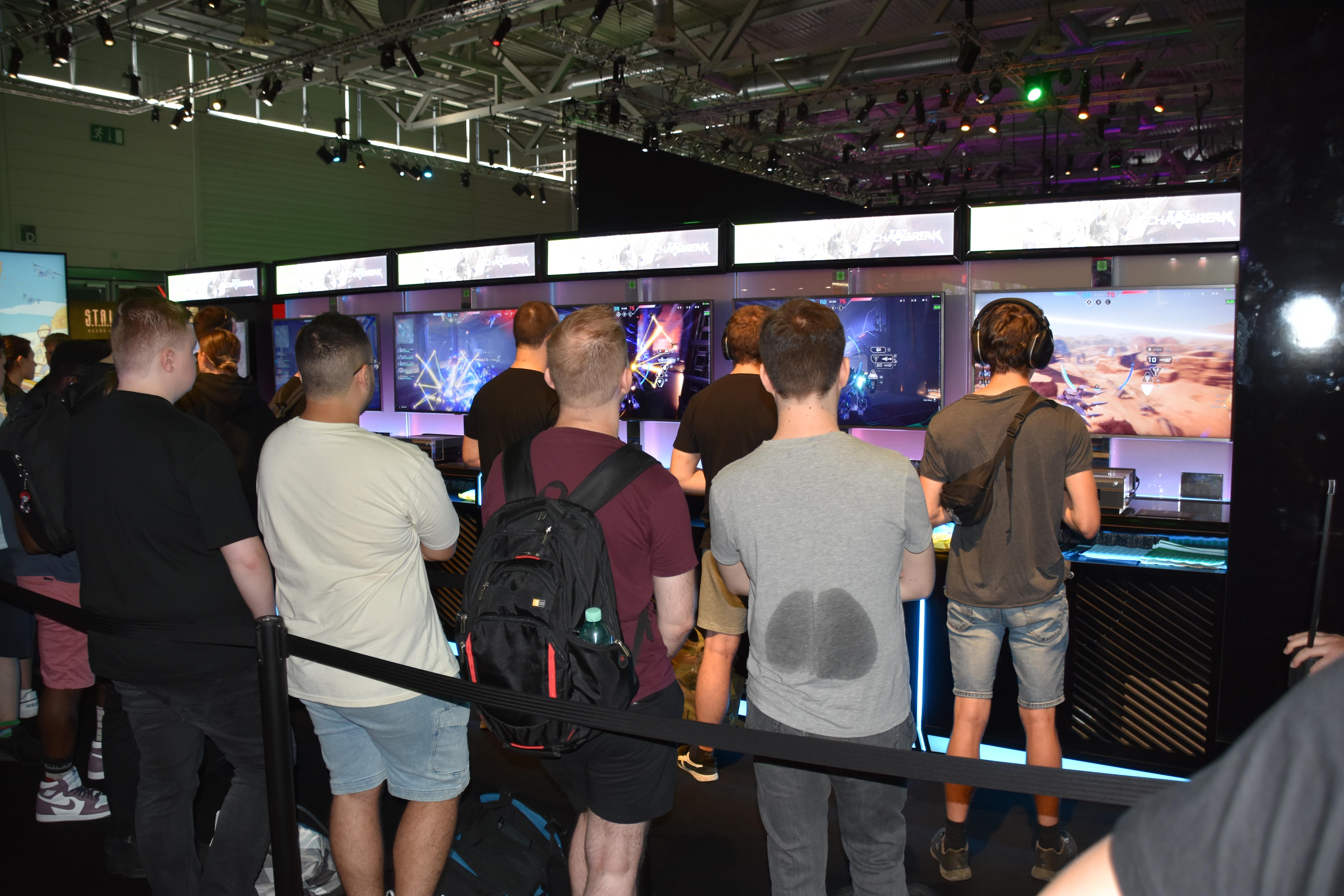 Gamer zocken auf einem Messestand auf der Gamescom 2024