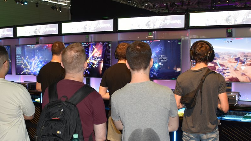 Gamer zocken auf einem Messestand auf der Gamescom 2024 | Bild: BR / Wolfgang Zehentmeier Gamer zocken auf einem Messestand auf der Gamescom 2024