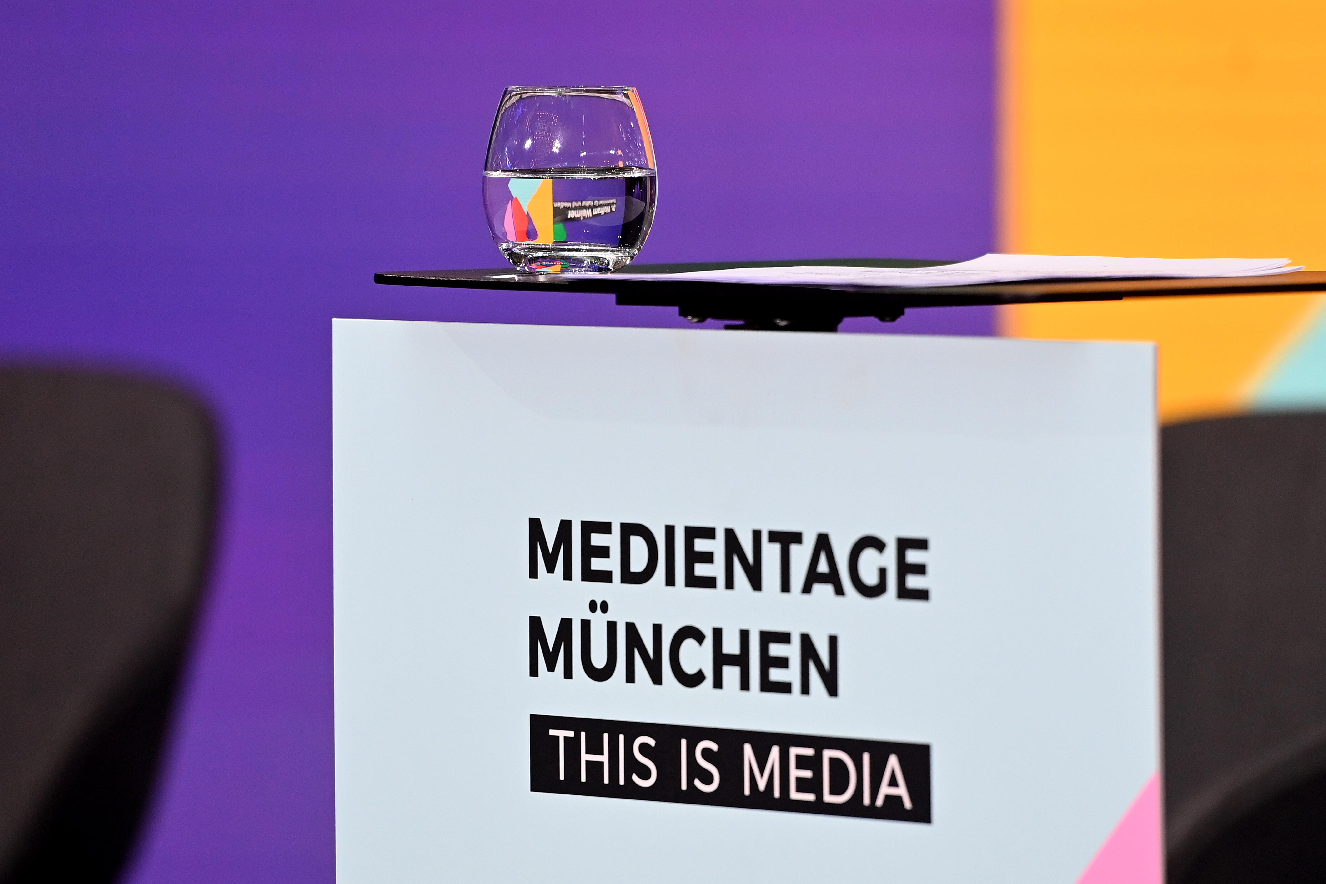 Ein Wasserglas steht auf einem Rednerpult bei den Medientagen München.