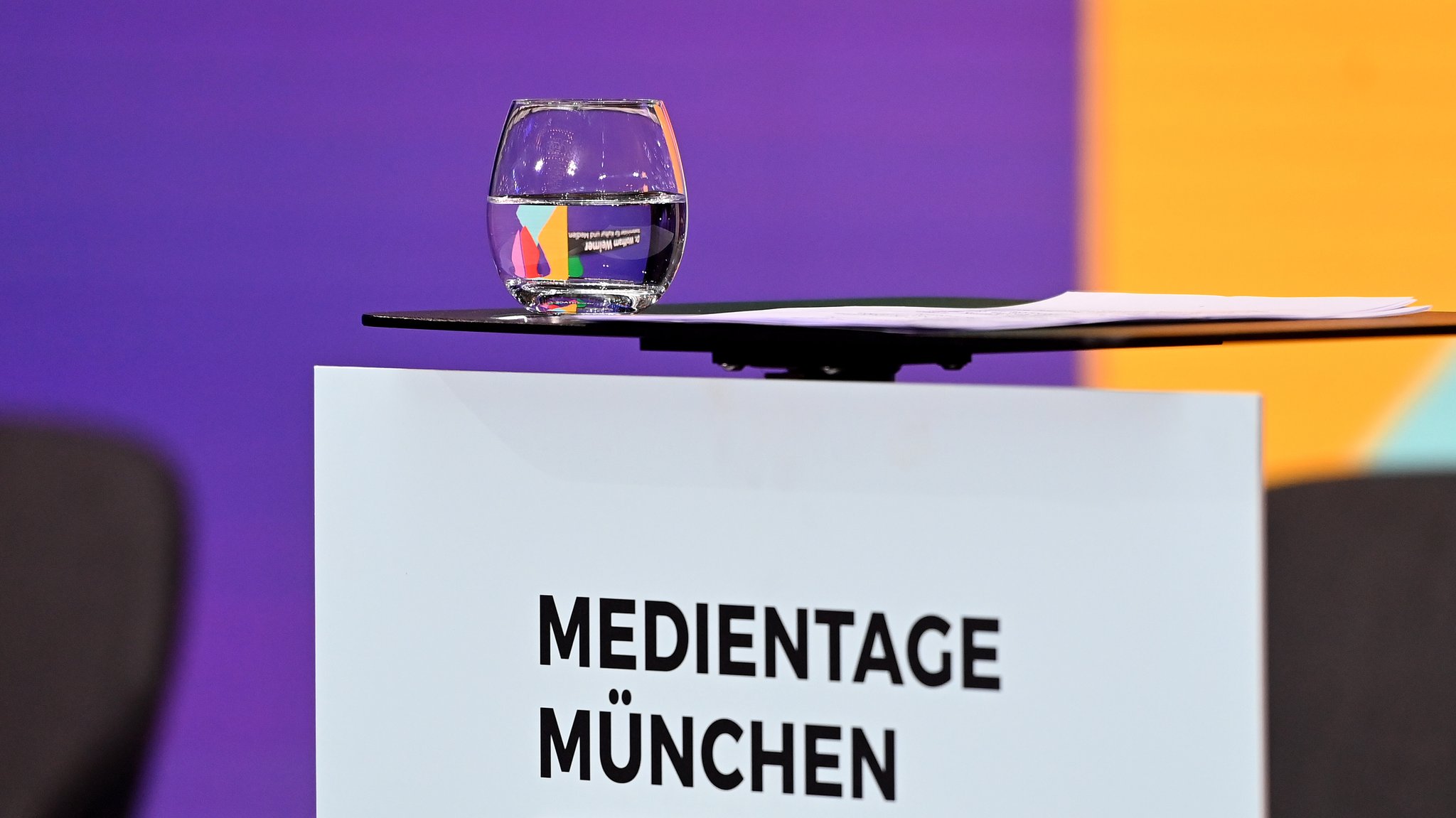 Ein Wasserglas steht auf einem Rednerpult bei den Medientagen München.