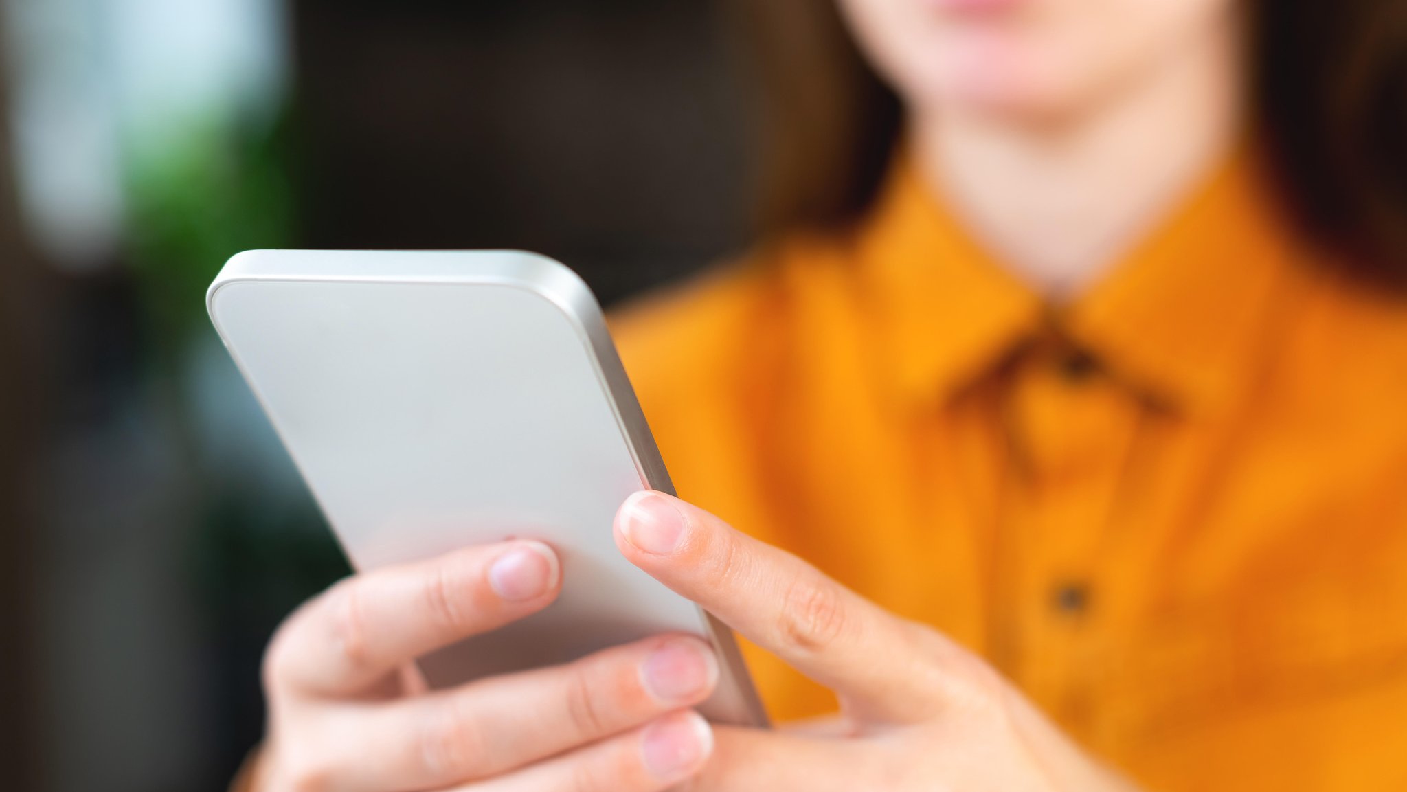 Frau blickt auf ein Smartphone.