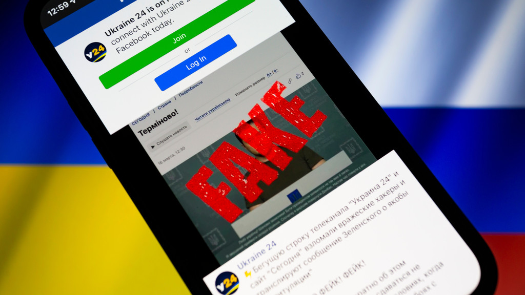 Facebook-Seite mit "FAKE" überschrieben vor russischer Fahne