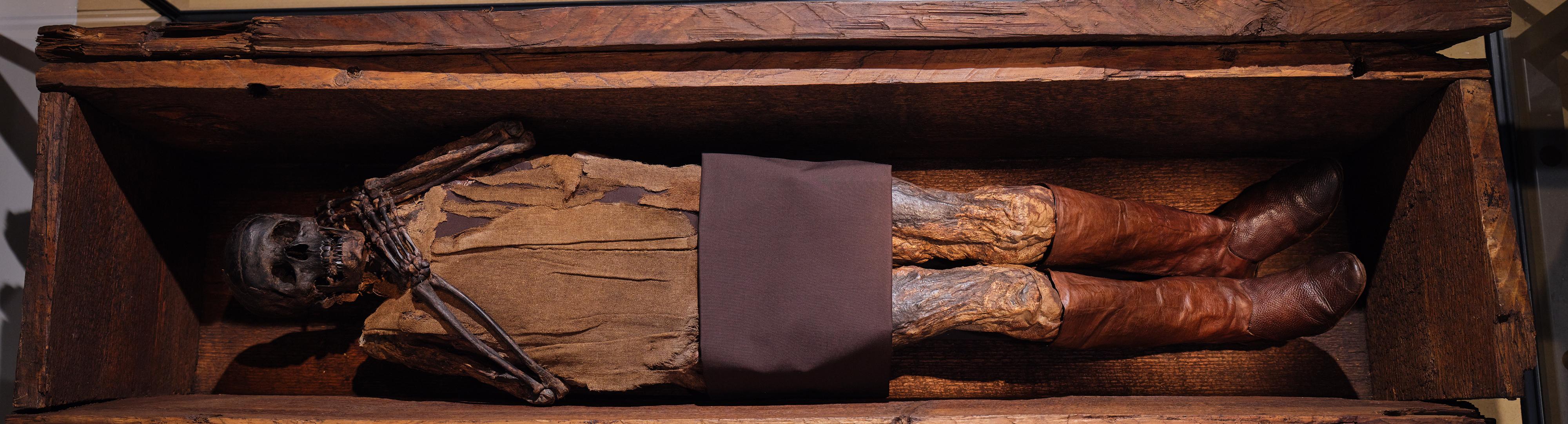 Dunkles Skelett mit Stoffresten am Oberkörper