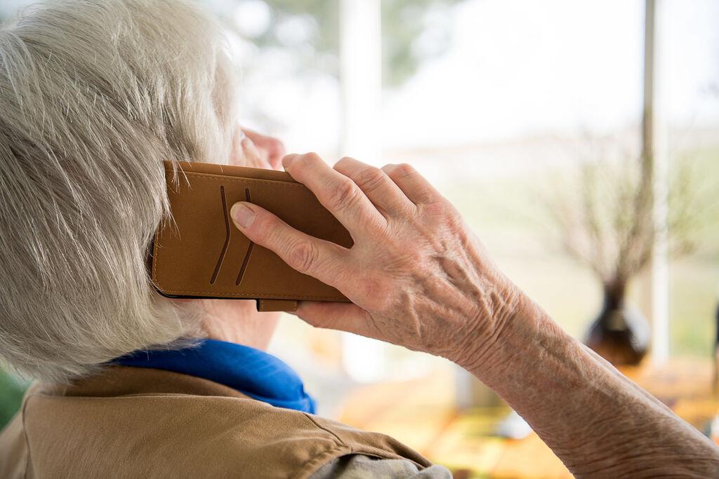 Eine Seniorin telefoniert mit ihrem Smartphone 