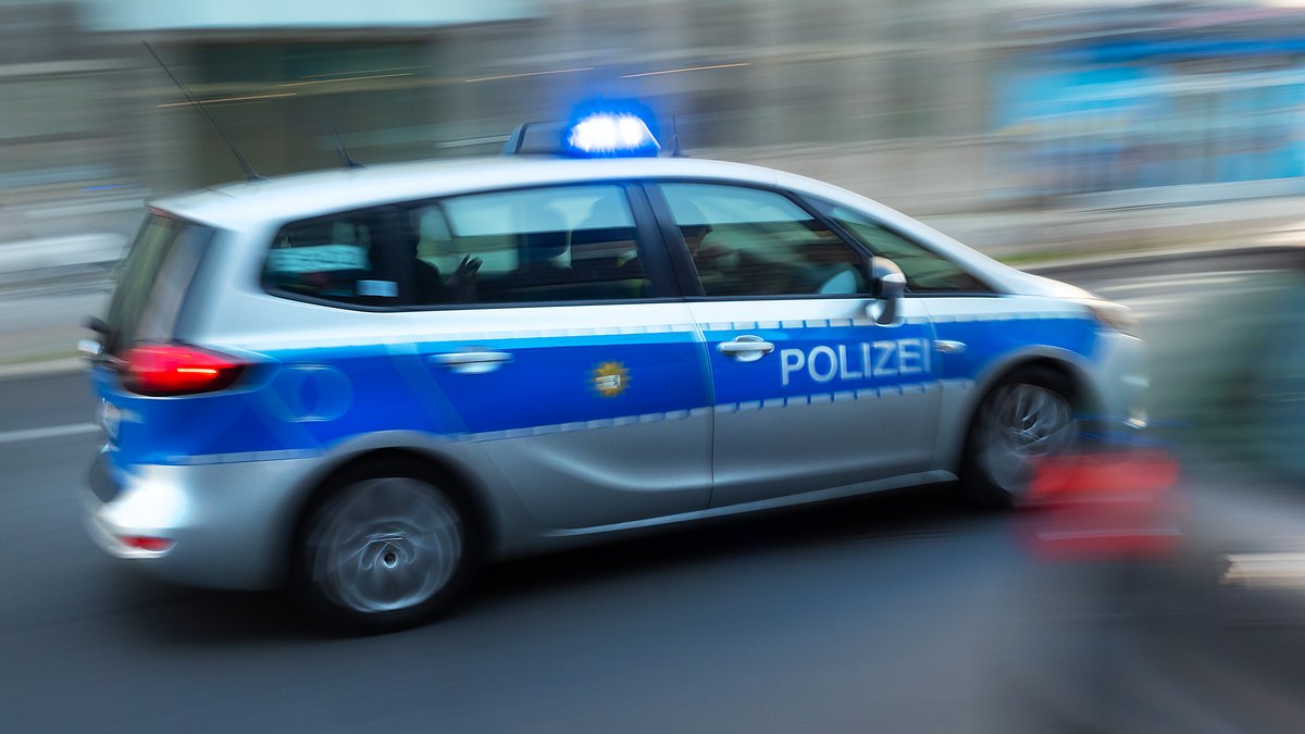 Ein Polizeiauto fährt mit Blaulicht über eine Straße in Berlin