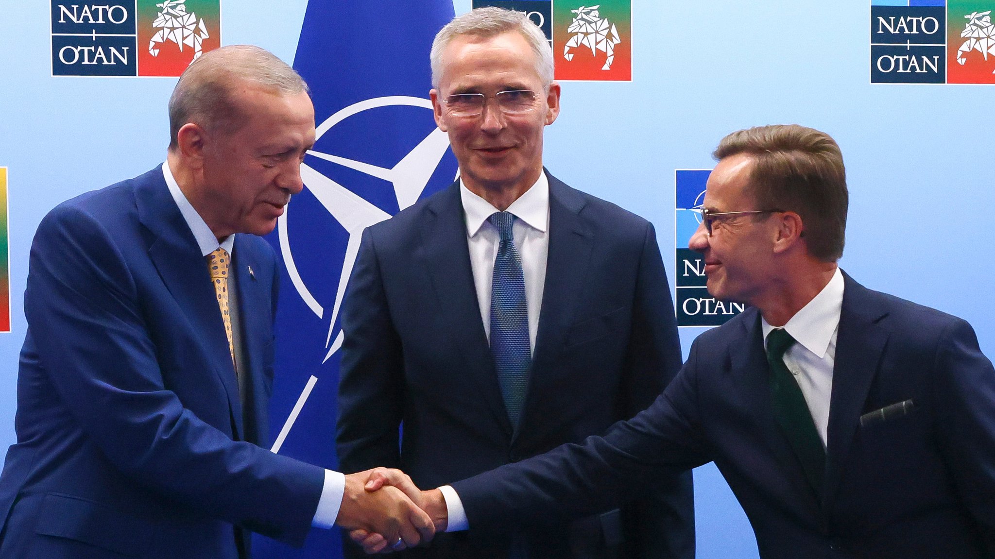 Der türkische Präsident Recep Tayyip Erdogan (links) schüttelt dem schwedischen Premierminister Ulf Kristersson (rechts) die Hand. In der Mitte: NATO-Generalsekretär Jens Stoltenberg.