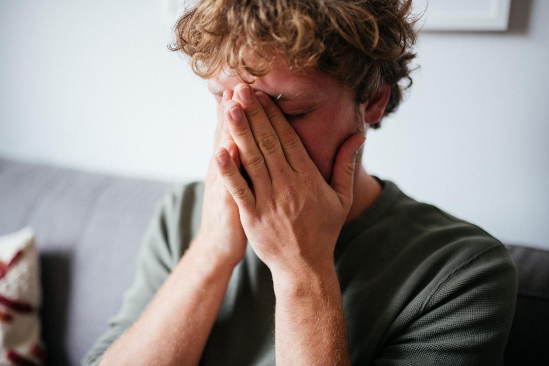 Ein Mann hält seine Hände vors Gesicht