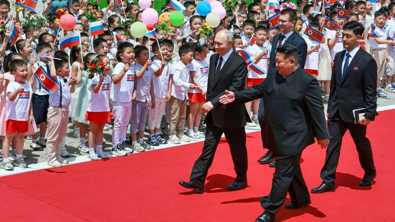 Die beiden Staatschefs schreiten eine Phalanx von Kindern ab, die Luftballons schwenken