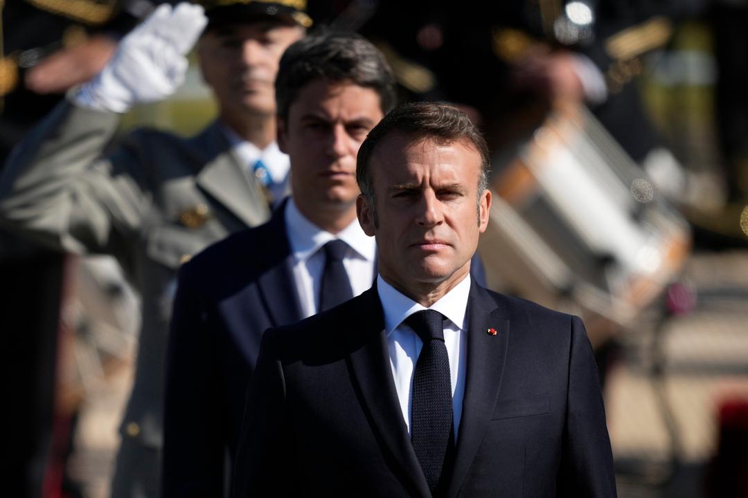 Der französische Präsident Emmanuel Macron (vorne) und Premierminister Gabriel Attal stehen während der Parade zum Tag der Bastille stramm.