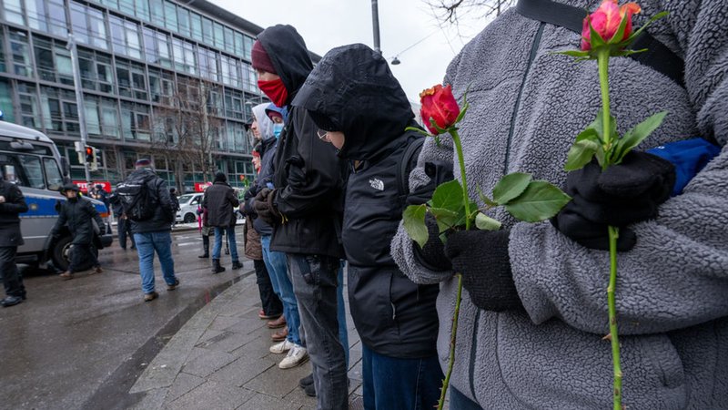 Frauen und Männer bilden eine Menschenkette um den Gedenkort für die Opfer des Anschlags und hindern andere daran, Blumen abzulegen. | Bild: dpa-Bildfunk/Pia Bayer Frauen und Männer bilden eine Menschenkette um den Gedenkort für die Opfer des Anschlags und hindern andere daran, Blumen abzulegen.