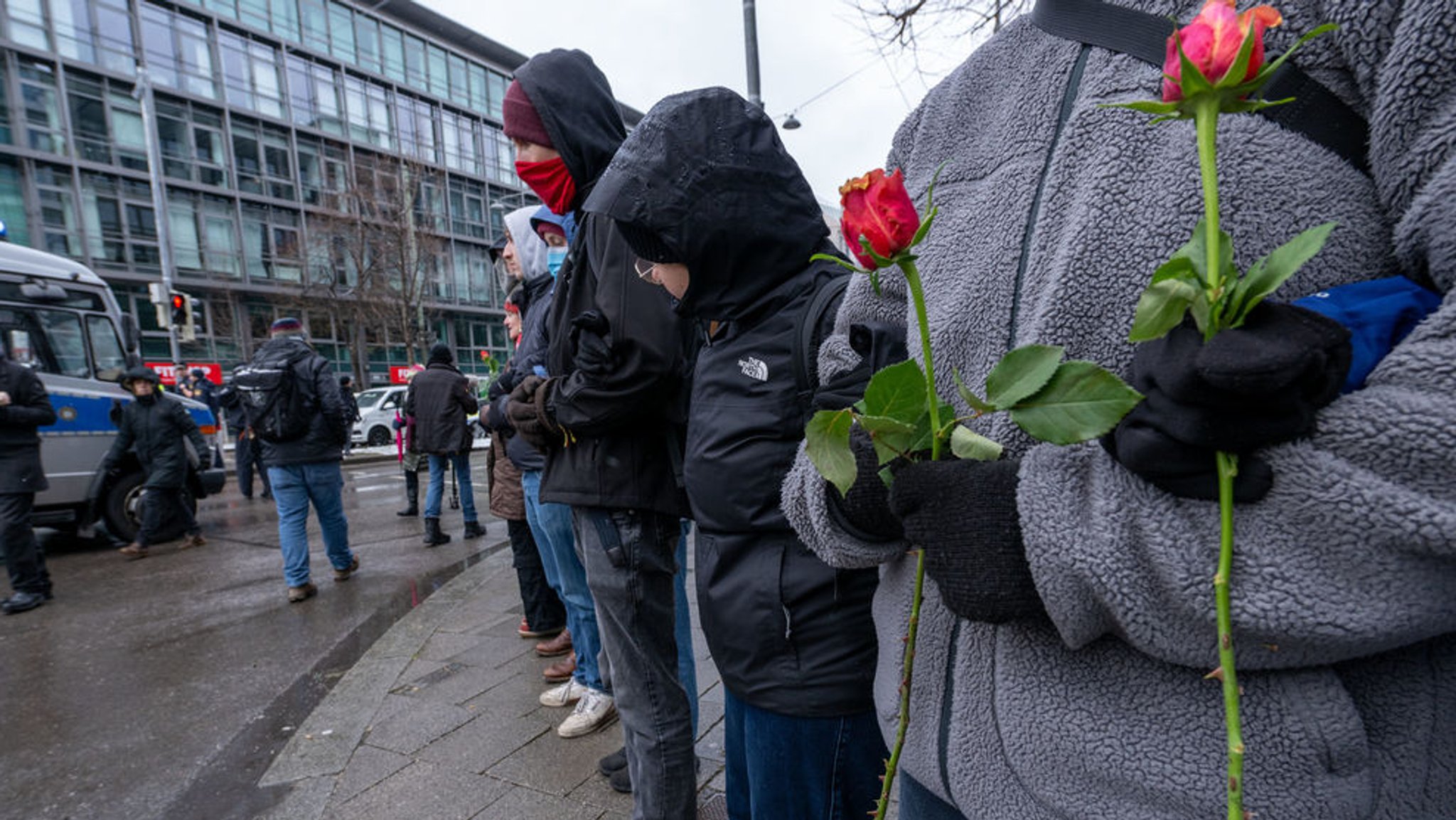 Frauen und Männer bilden eine Menschenkette um den Gedenkort für die Opfer des Anschlags und hindern andere daran, Blumen abzulegen. 