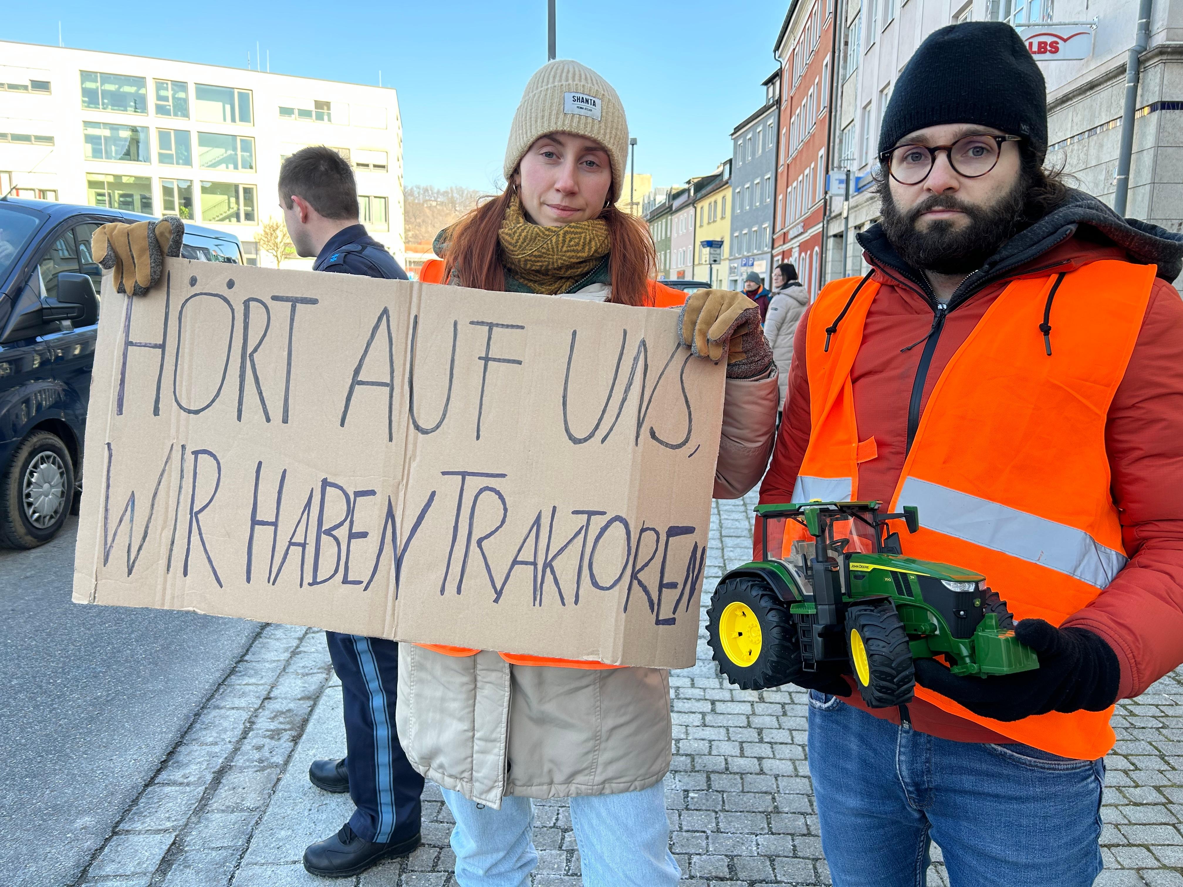Klimaaktivisten mit einem Schild: "Hört auf uns, wir haben Traktoren". 