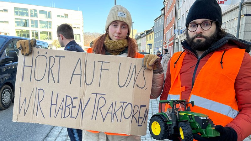 Klimaaktivisten mit einem Schild: "Hört auf uns, wir haben Traktoren". 