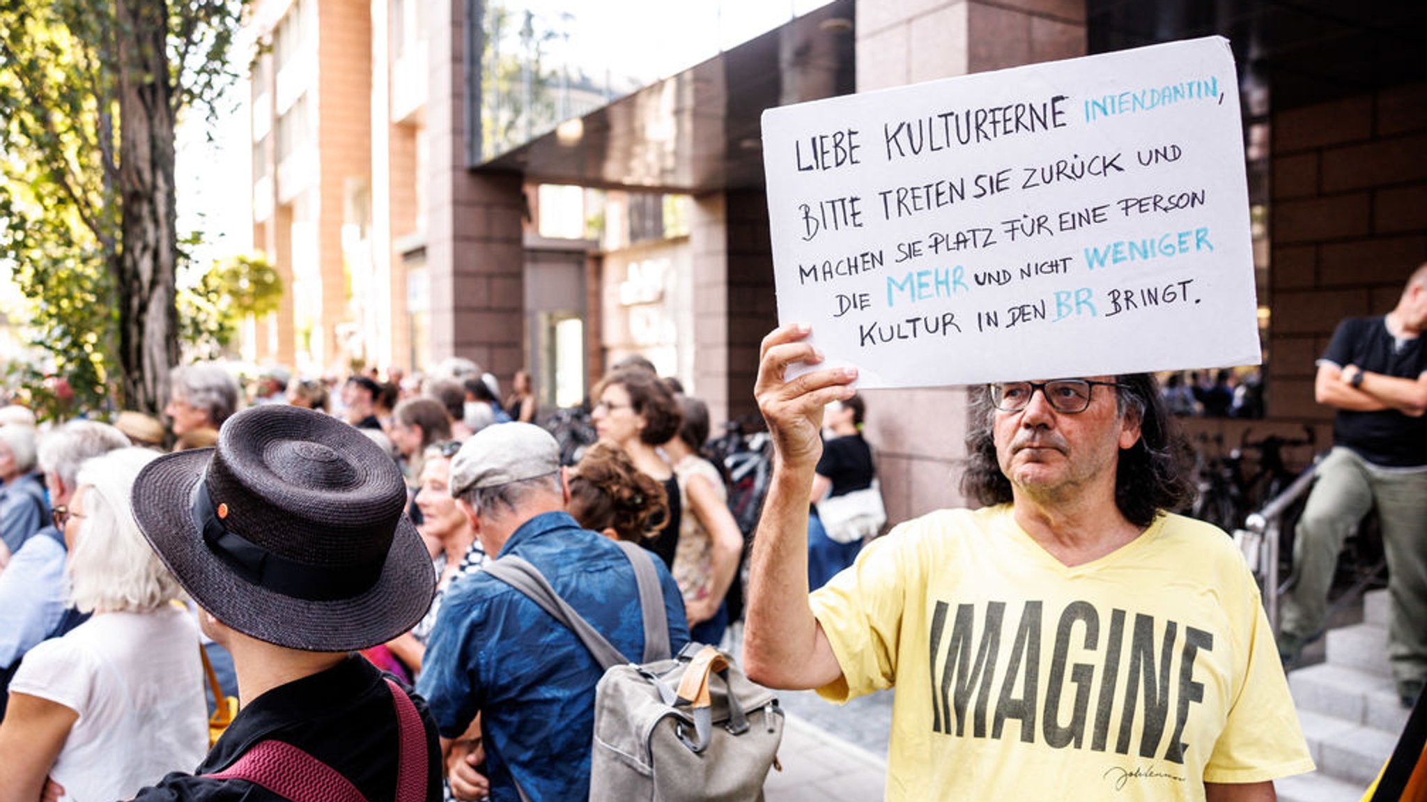 Ein Mann hält während einer Demonstration von Kulturschaffenden und Journalisten gegen die geplanten Programmkürzungen beim Bayerischen Rundfunk (BR) ein Plakat mit der Aufschrift ·Liebe kulturferne Intendantin, bitte treten Sie zurück und machen Sie Platz für eine Person, die mehr und nicht weniger Kultur in den BR bringt·. Foto: Matthias Balk/dpa +++ dpa-Bildfunk +++