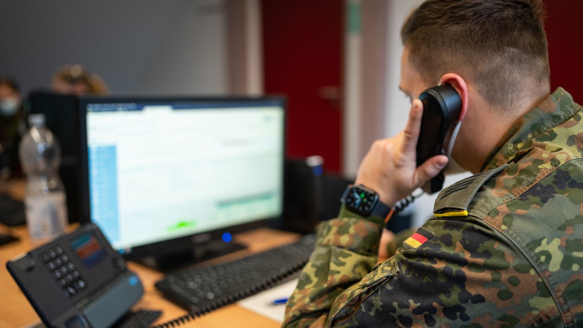 Soldat der Bundeswehr telefoniert und schaut in den Computer