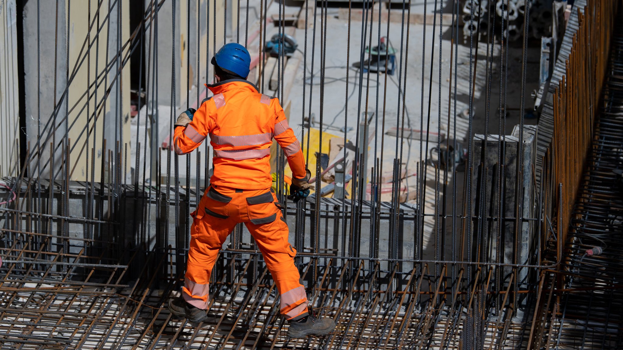 Bayern, München: Ein Bauarbeiter verlegt auf einer Baustelle Stahlmatten.