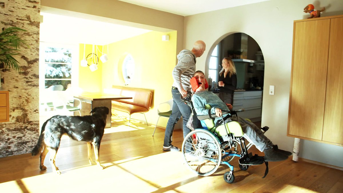 Wohnzimmer mit Familie mit Junge im Rollstuhl