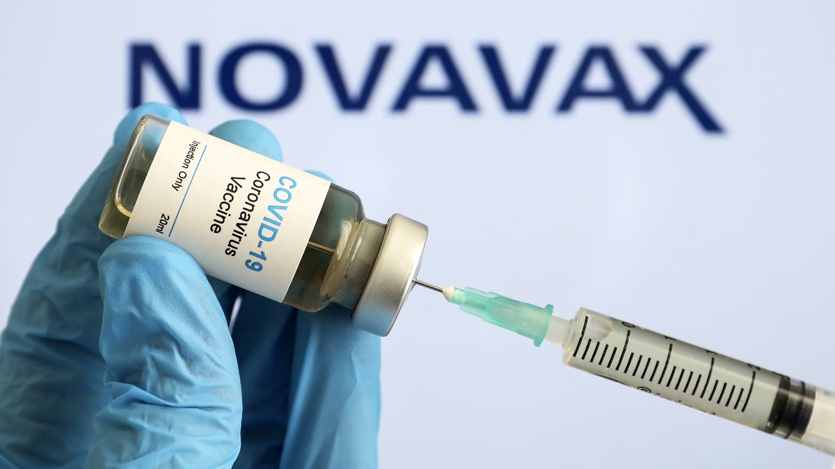 Spritze und Ampulle, gehalten von Hand mit blauem Kunststoffhandschuh, Schriftzug Novavax