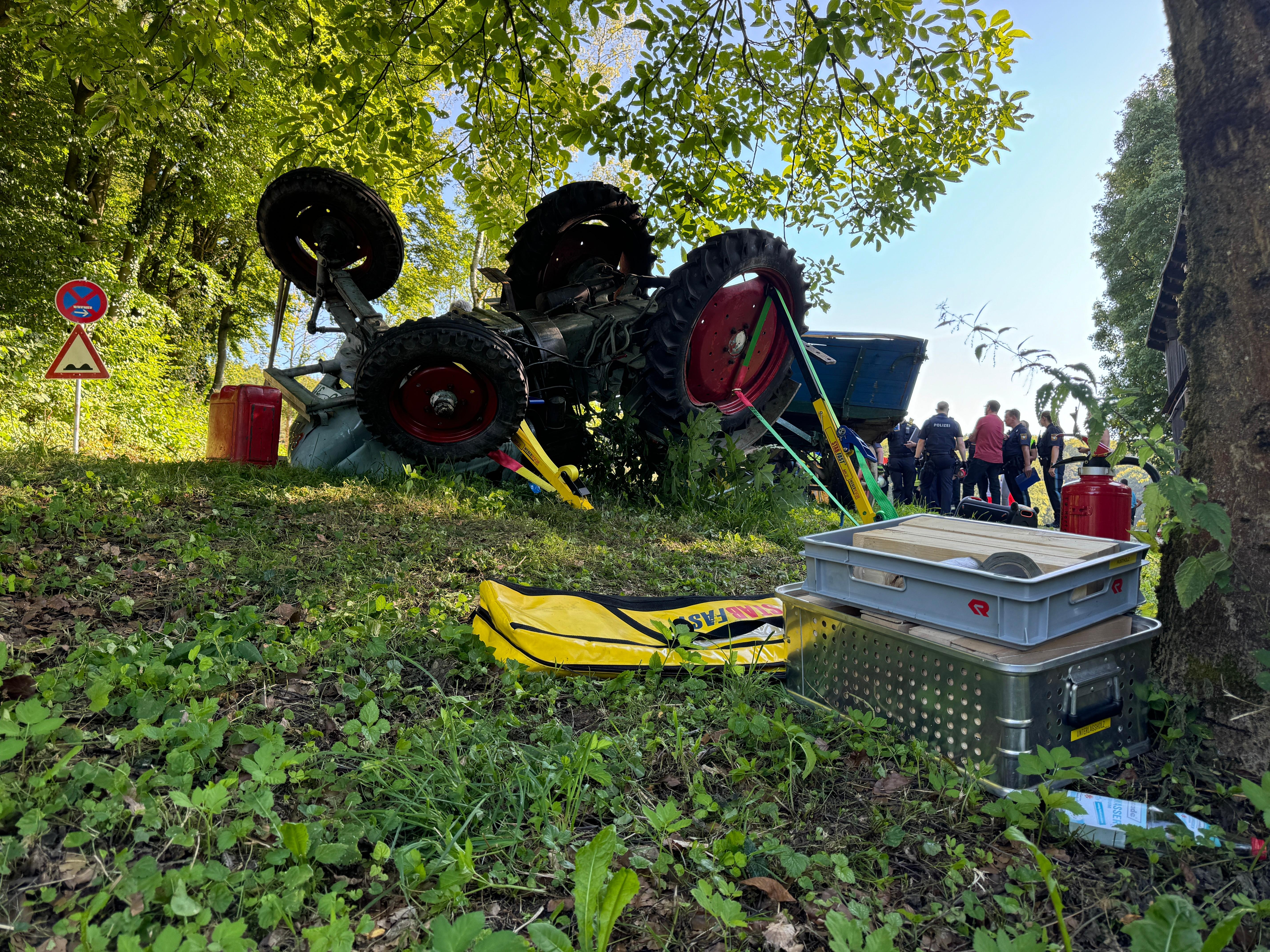 Ein Traktor liegt in einem Waldstück auf dem Kopf