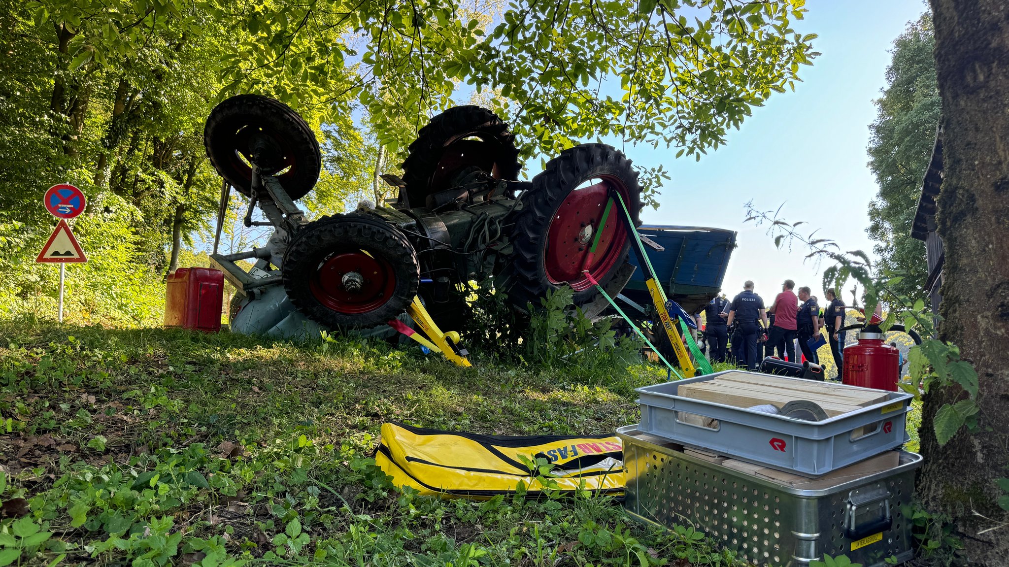 Ein Traktor liegt in einem Waldstück auf dem Kopf