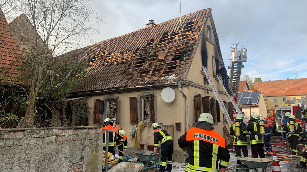 Feuerwehrleute räumen Schutt und Müll aus dem zuvor gelöschten Wohnhaus im Dettelbacher Ortsteil Schernau