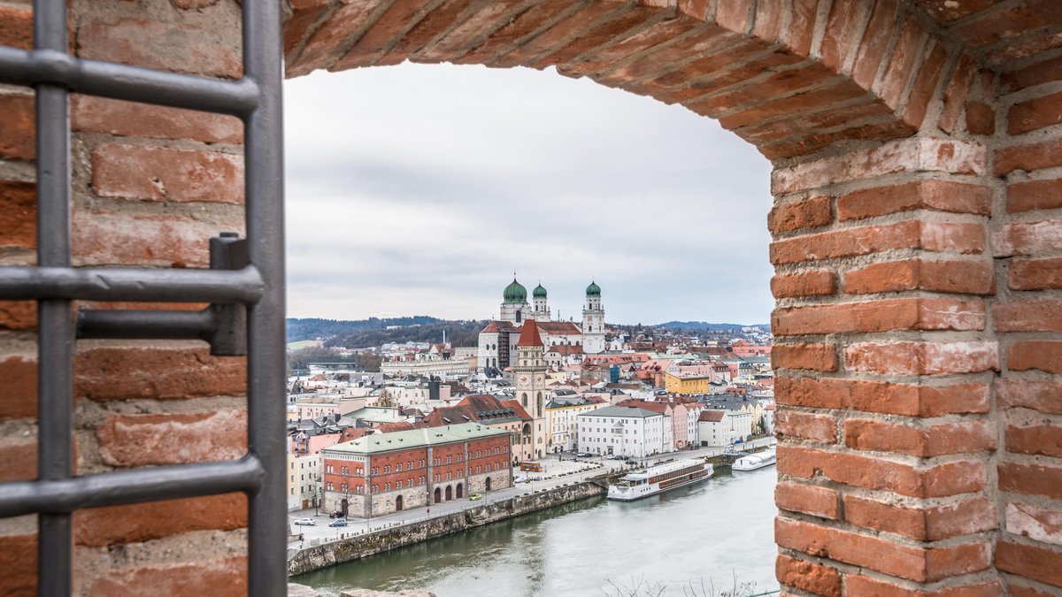 Blick durch einen steinernen Bogen auf die Stadt Passau