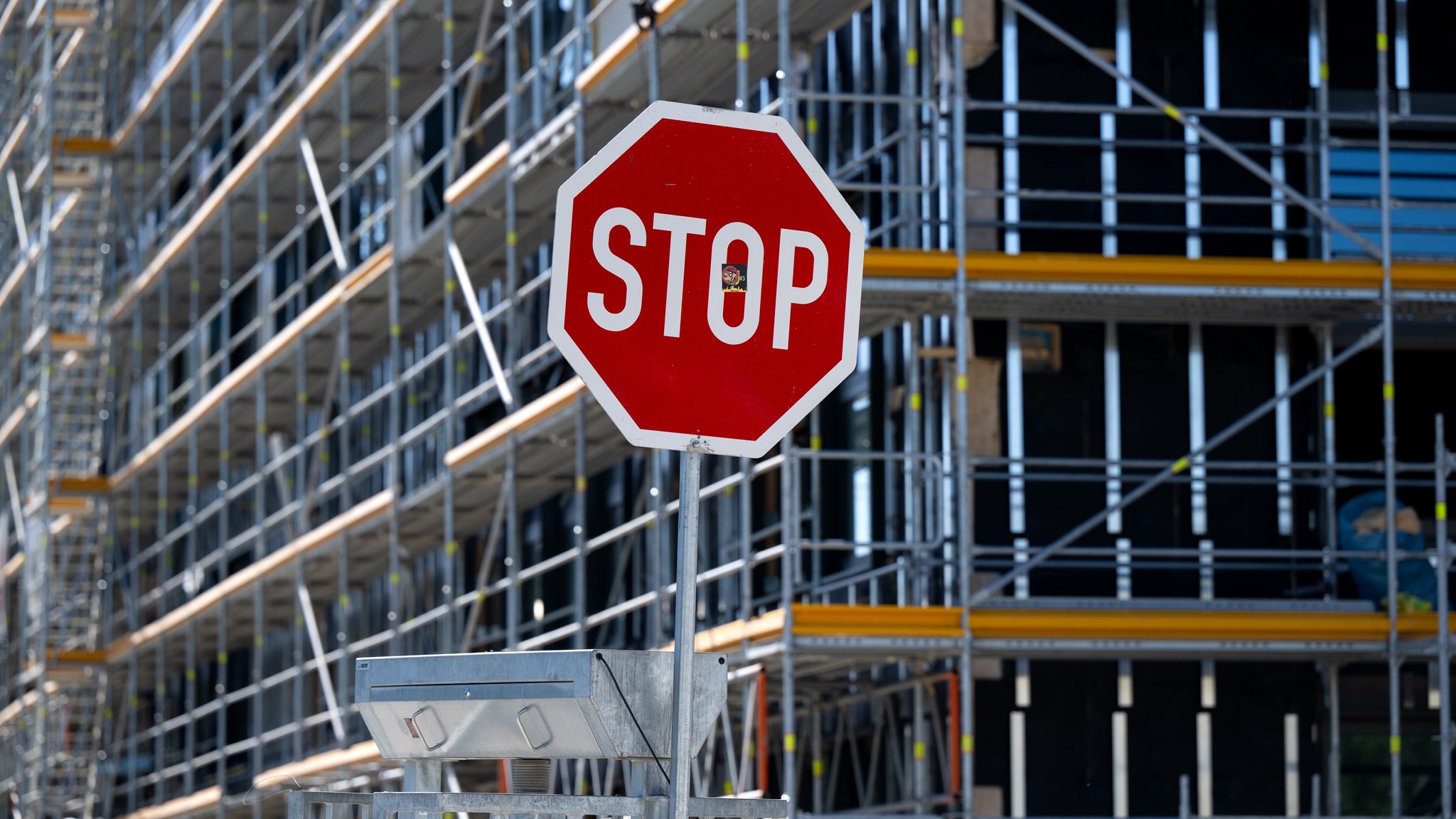 Ein Stoppschild steht auf der Baustelle eines Neubaus.