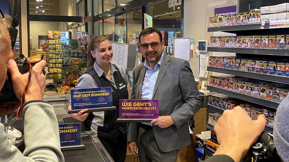 Bayerns Gesundheitsminister Klaus Holetschek steht neben einer Verkäuferin an der Supermarkt-"Ratschkasse" in Buxheim | Bild:Bayerisches Gesundheitsministerium