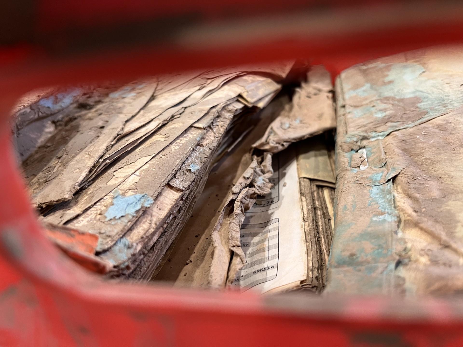 Schlammspuren auf Akten in einer roten Plastikiste | Bild:BR/ Doris Bimmer