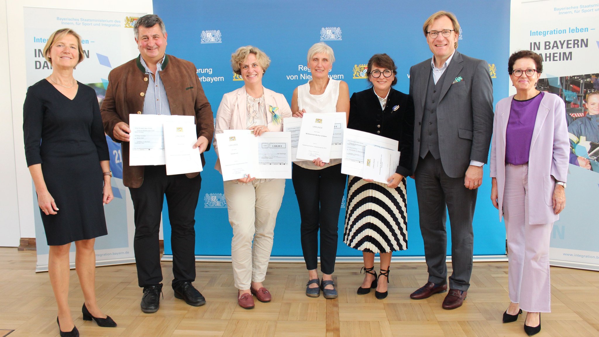 Menschen mit Urkunden in der Hand bei einem Gruppenfoto