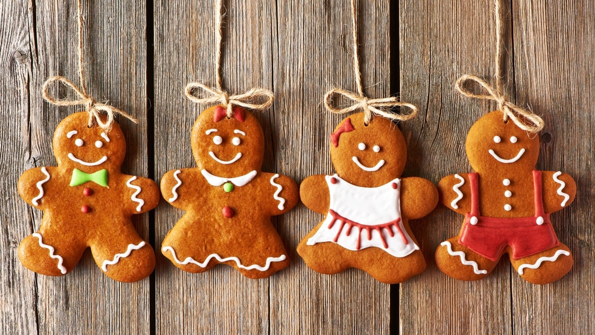 Lebkuchenmännchen auf einem Holzuntergrund. Um das klassisch-köstliche Weihnachtsgebäck ranken sich viele bunte Geschichten. Eine der glaubwürdigsten: Der Lebkuchen soll angeblich aus Not entstanden sein, weil Mehl fehlte. 